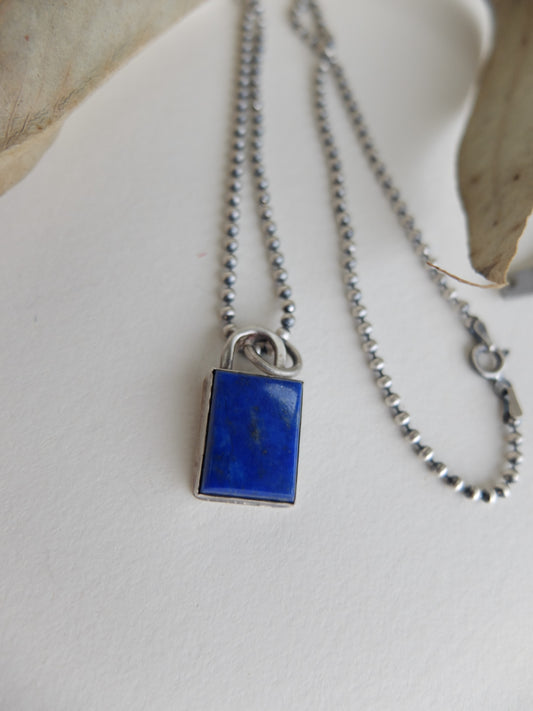 Necklace with a blue Lapis Lazuli square pendant on a light background