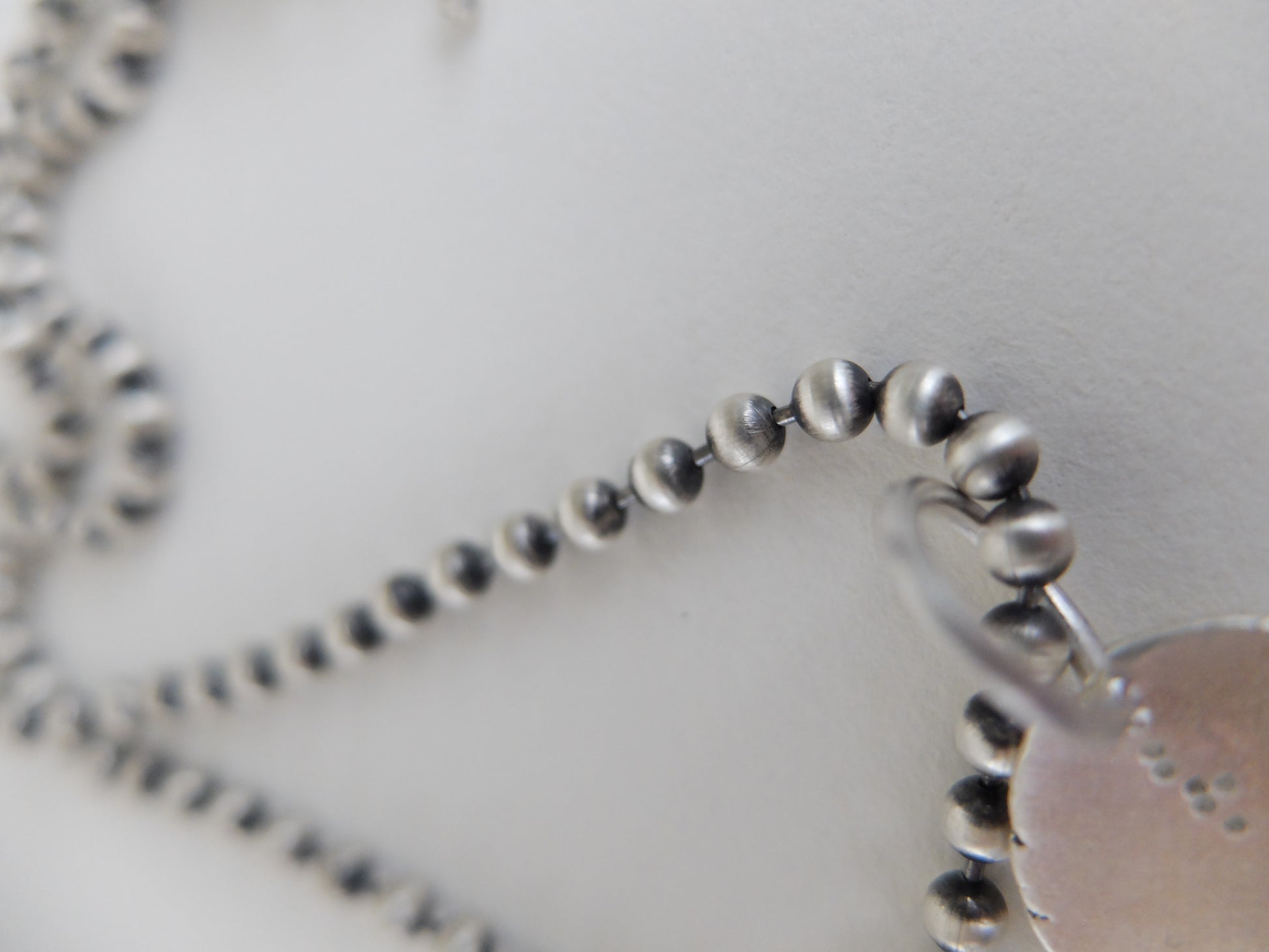 Close-up of a silver beaded bracelet on a white background