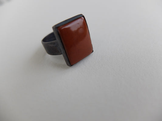 Ring with a brown square stone on a light gray background