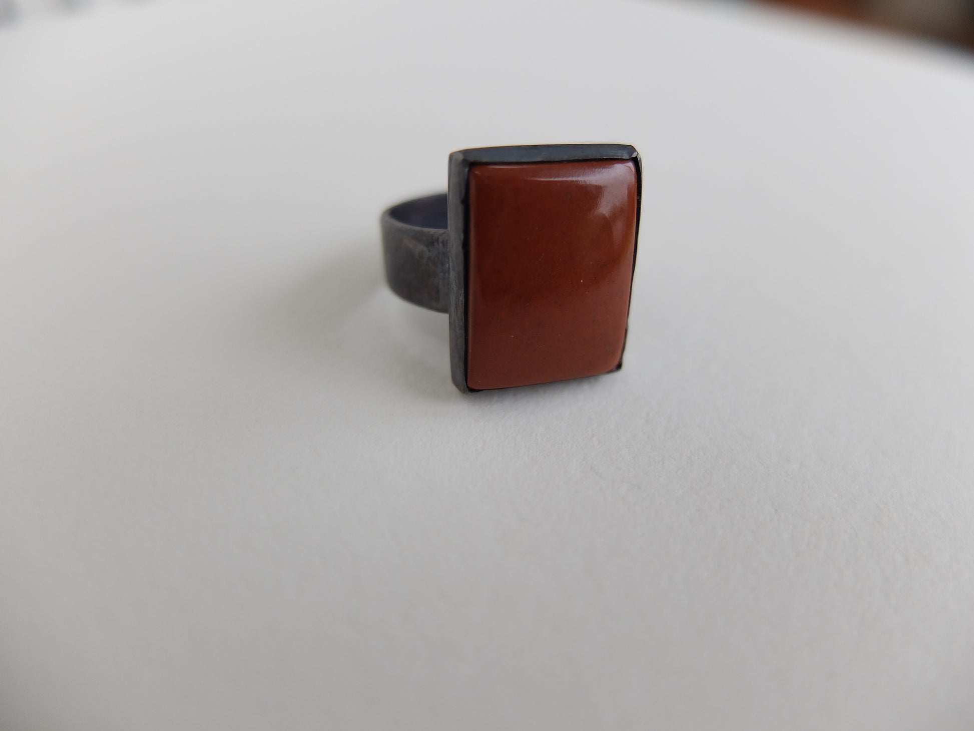 Ring with a brown square stone on a light gray background