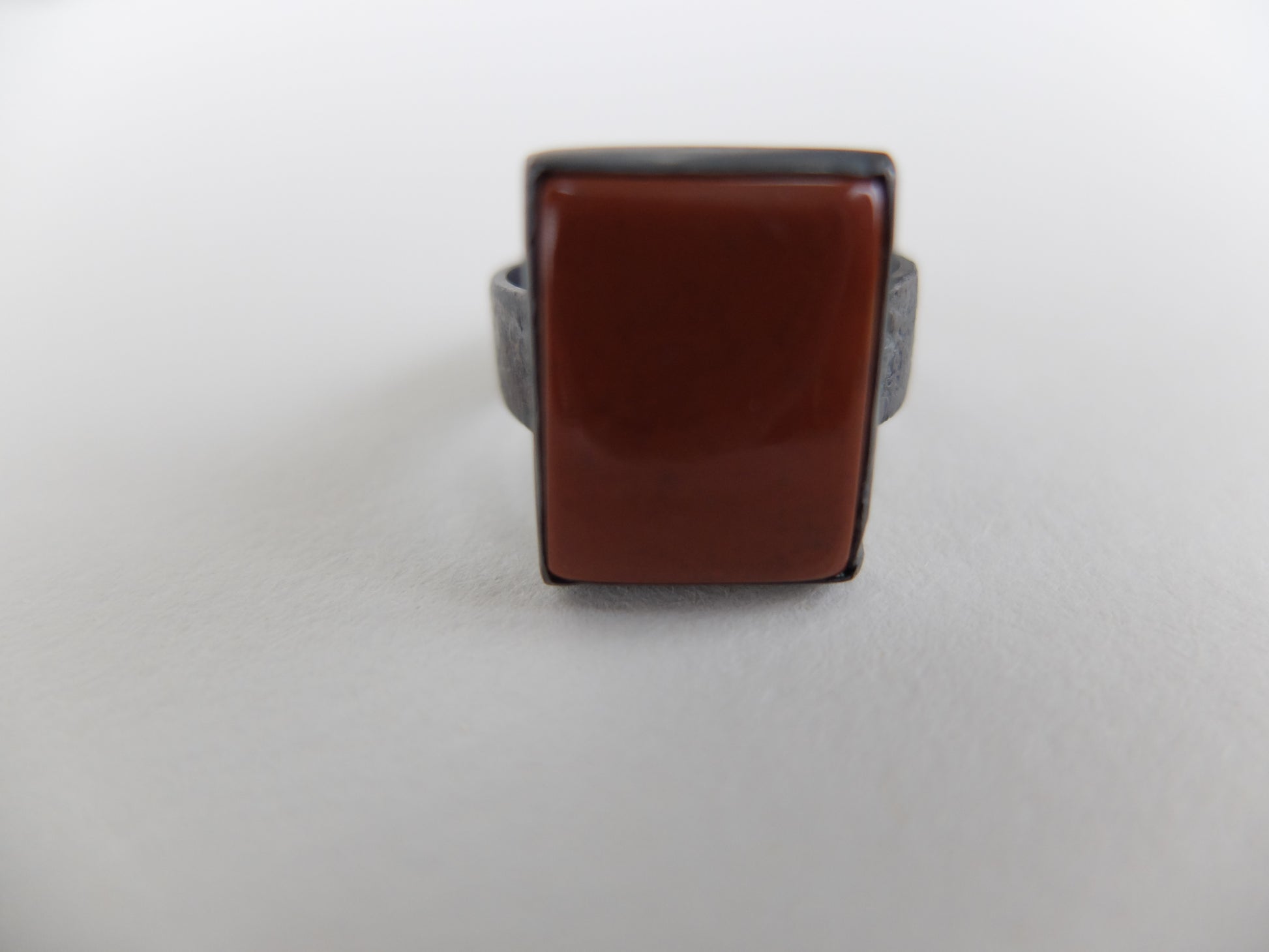 Ring with a brown square stone on a white background