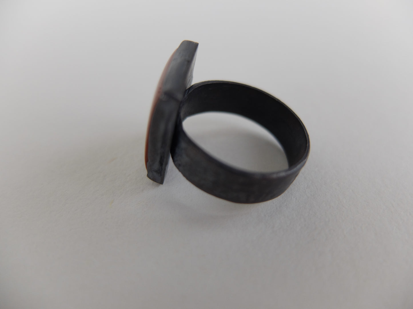 Black ring with a unique design on a white background