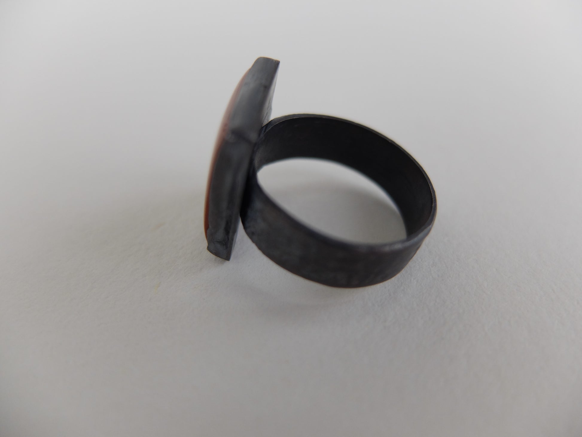 Black ring with a unique design on a white background