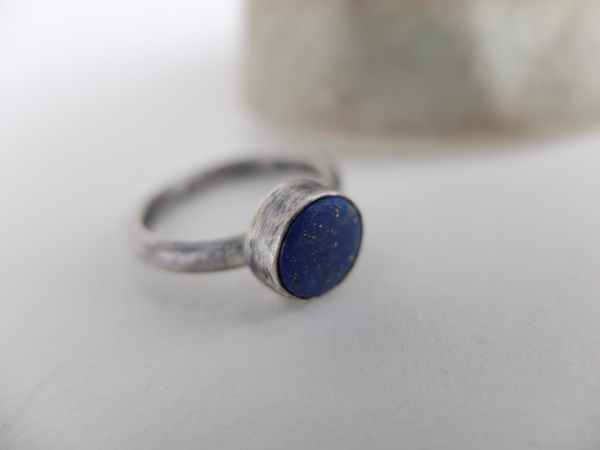 Silver ring with a blue lapis lazuli stone on a light background