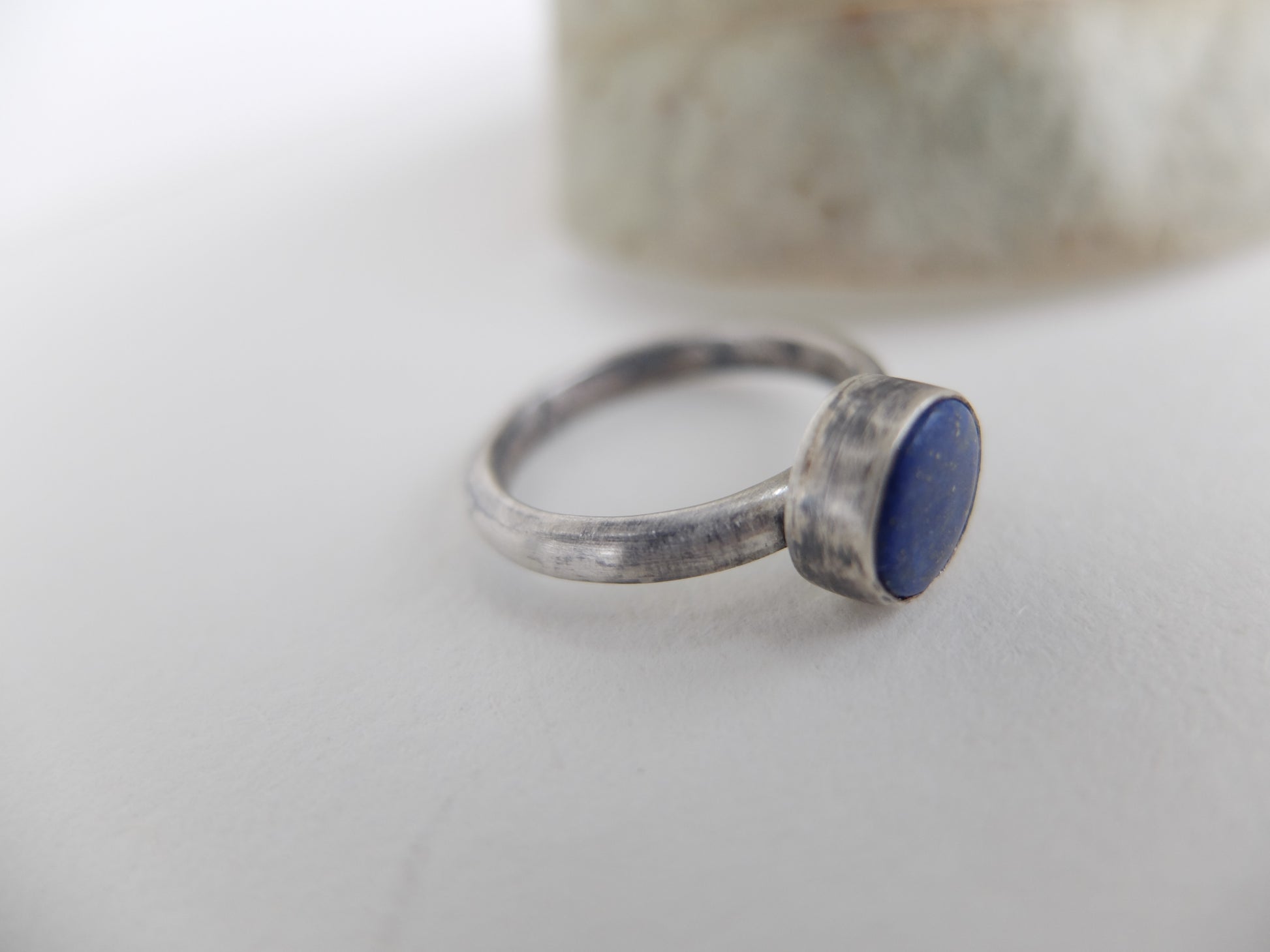 Silver ring with a blue lapis lazuli stone on a light background