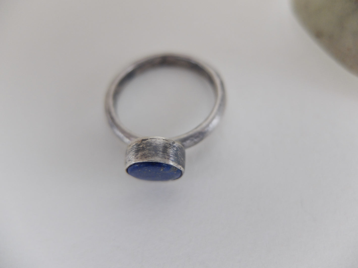 Silver ring with a blue stone on a white background