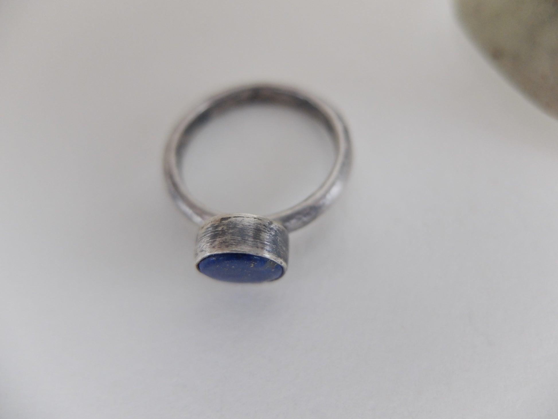 Silver ring with a blue stone on a white background