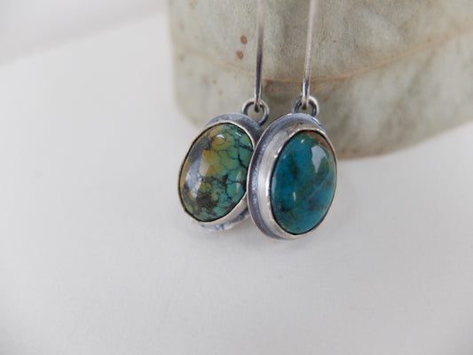 Silver earrings with turquoise stones on a light background