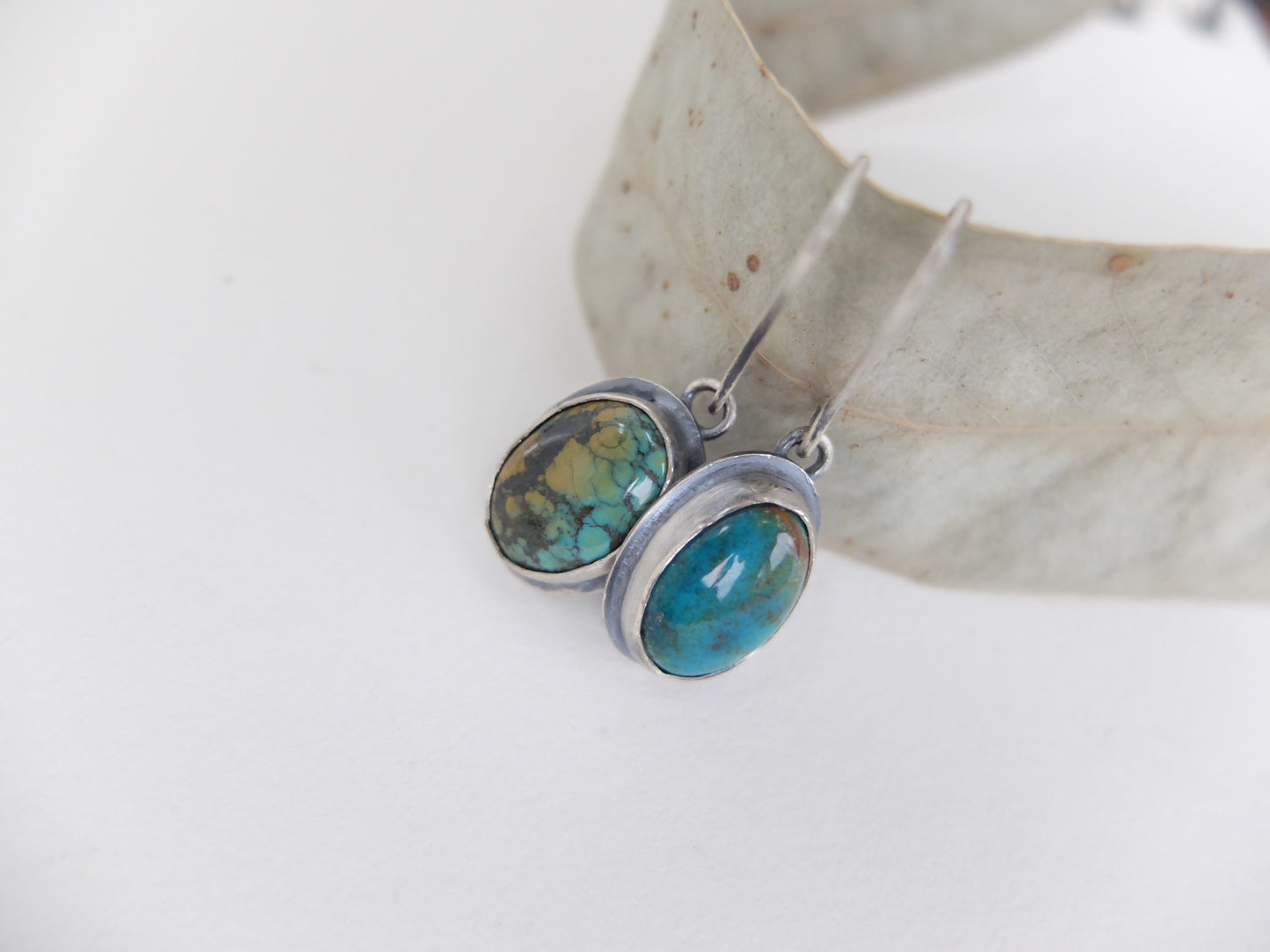 Pair of earrings with turquoise stones on a white background