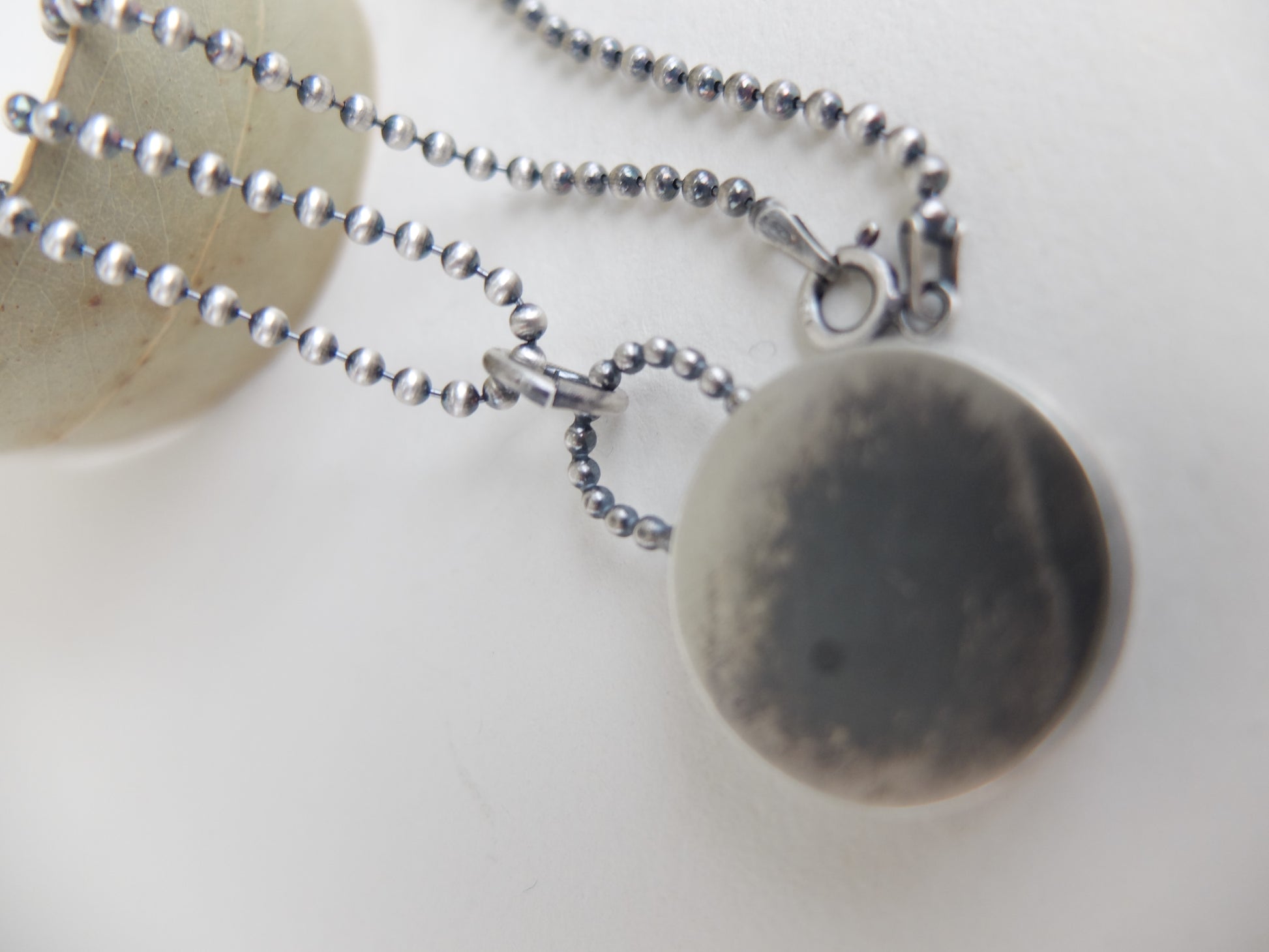 Necklace with a round pendant on a light background