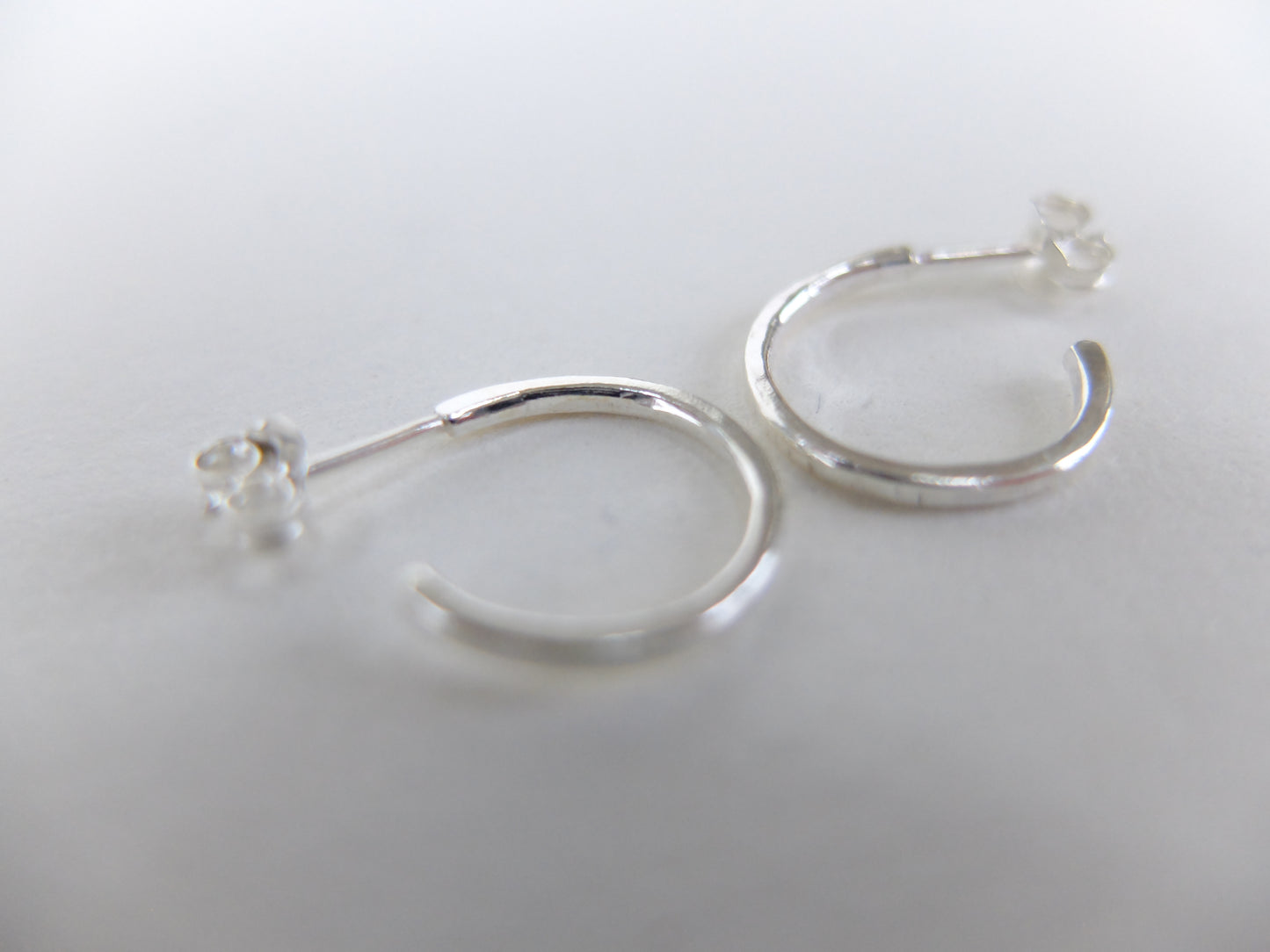 Silver hoop earrings on a light gray background