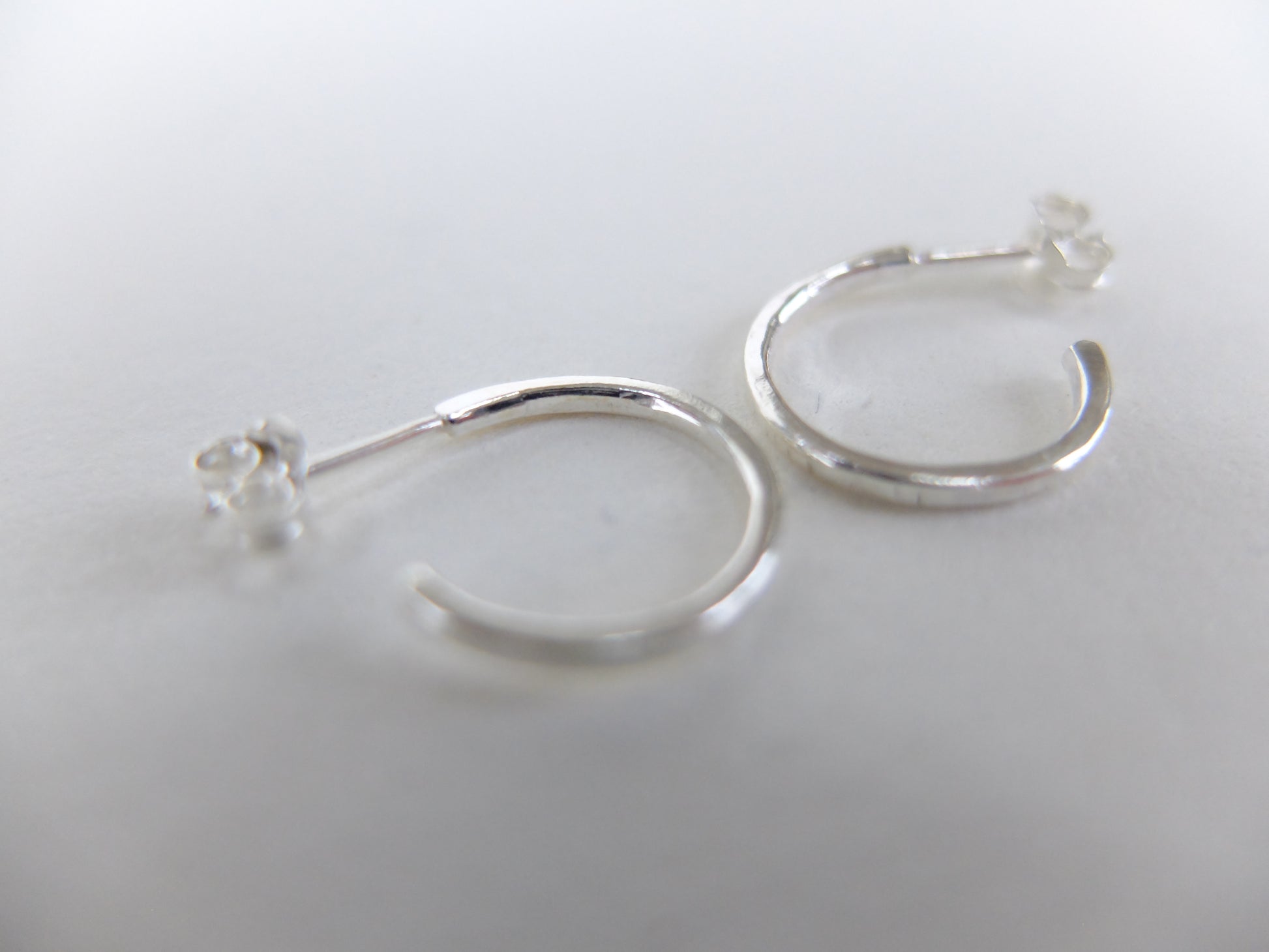 Silver hoop earrings on a light gray background