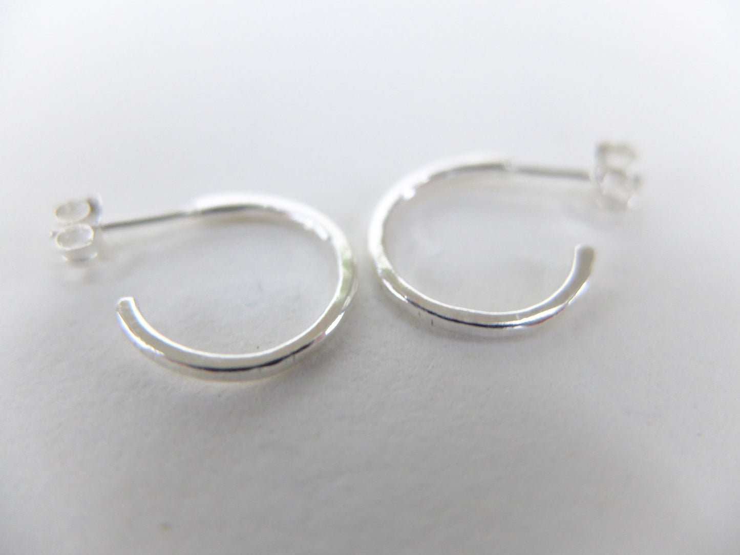 Silver hoop earrings on a light gray background