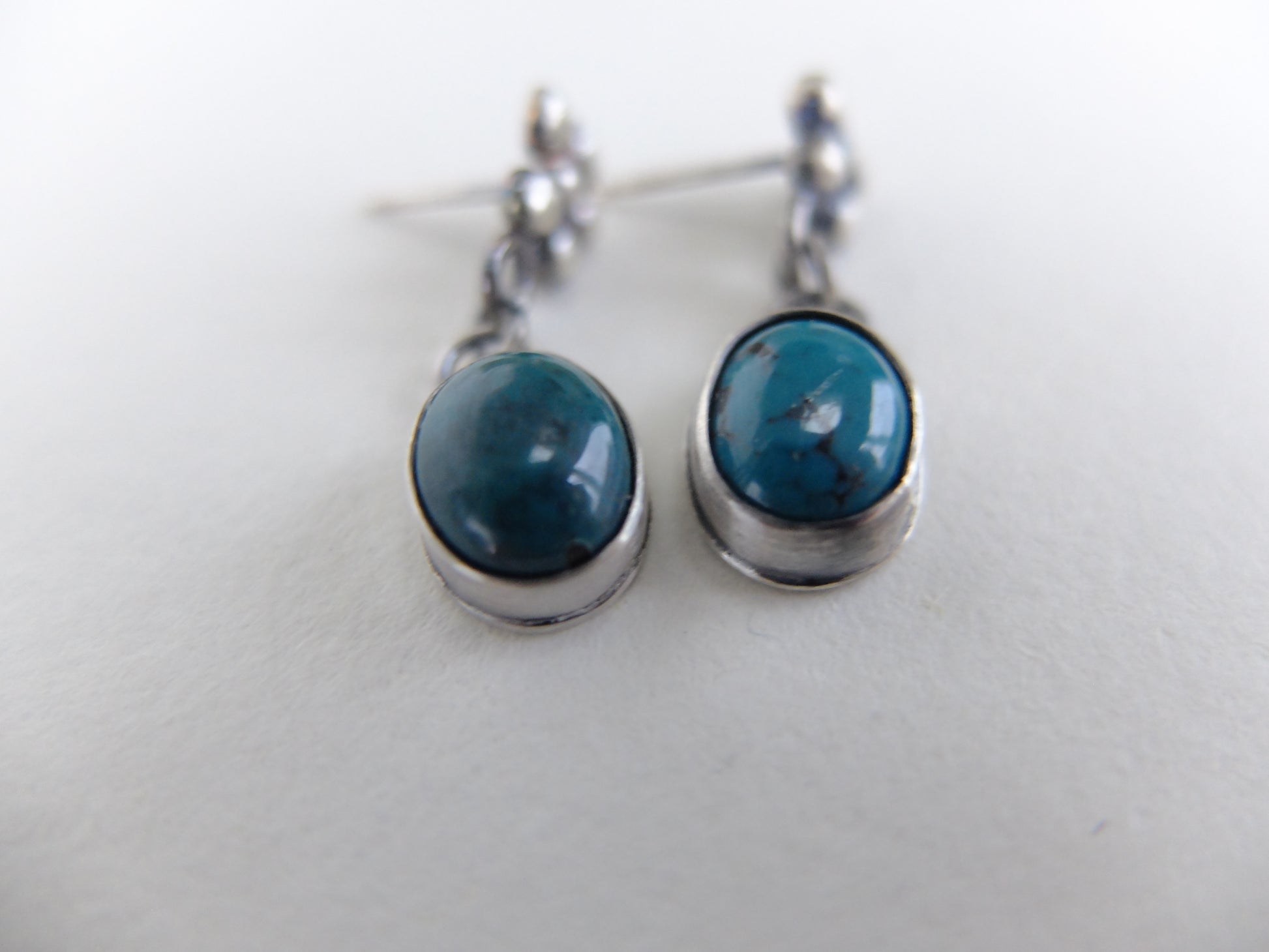 Pair of earrings with blue stones on a white background