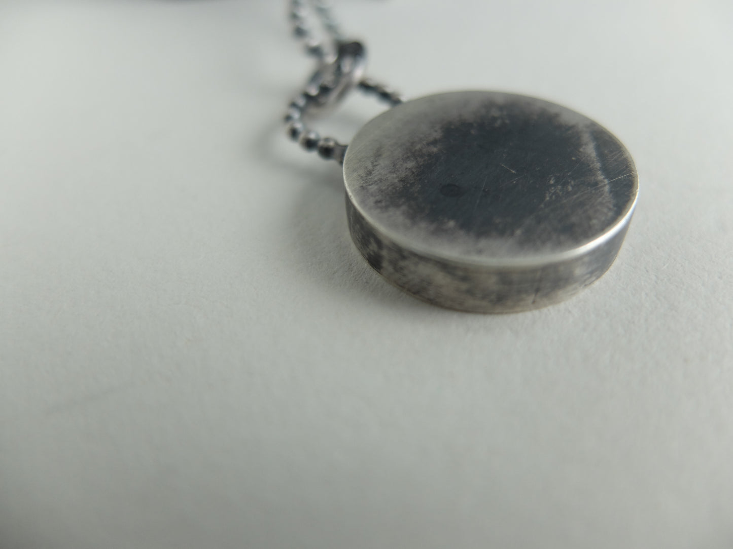 Silver pendant necklace on a light gray background