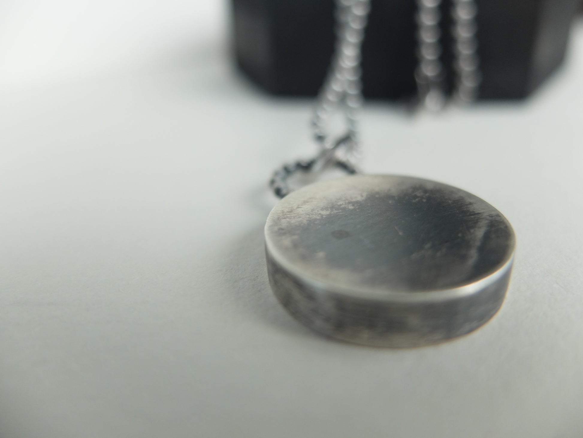 Close-up of a silver pendant on a blurred background