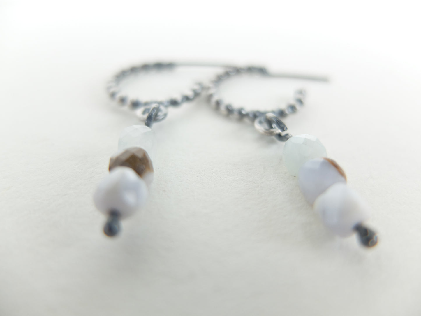 Close-up of  earrings with white beads on a light background