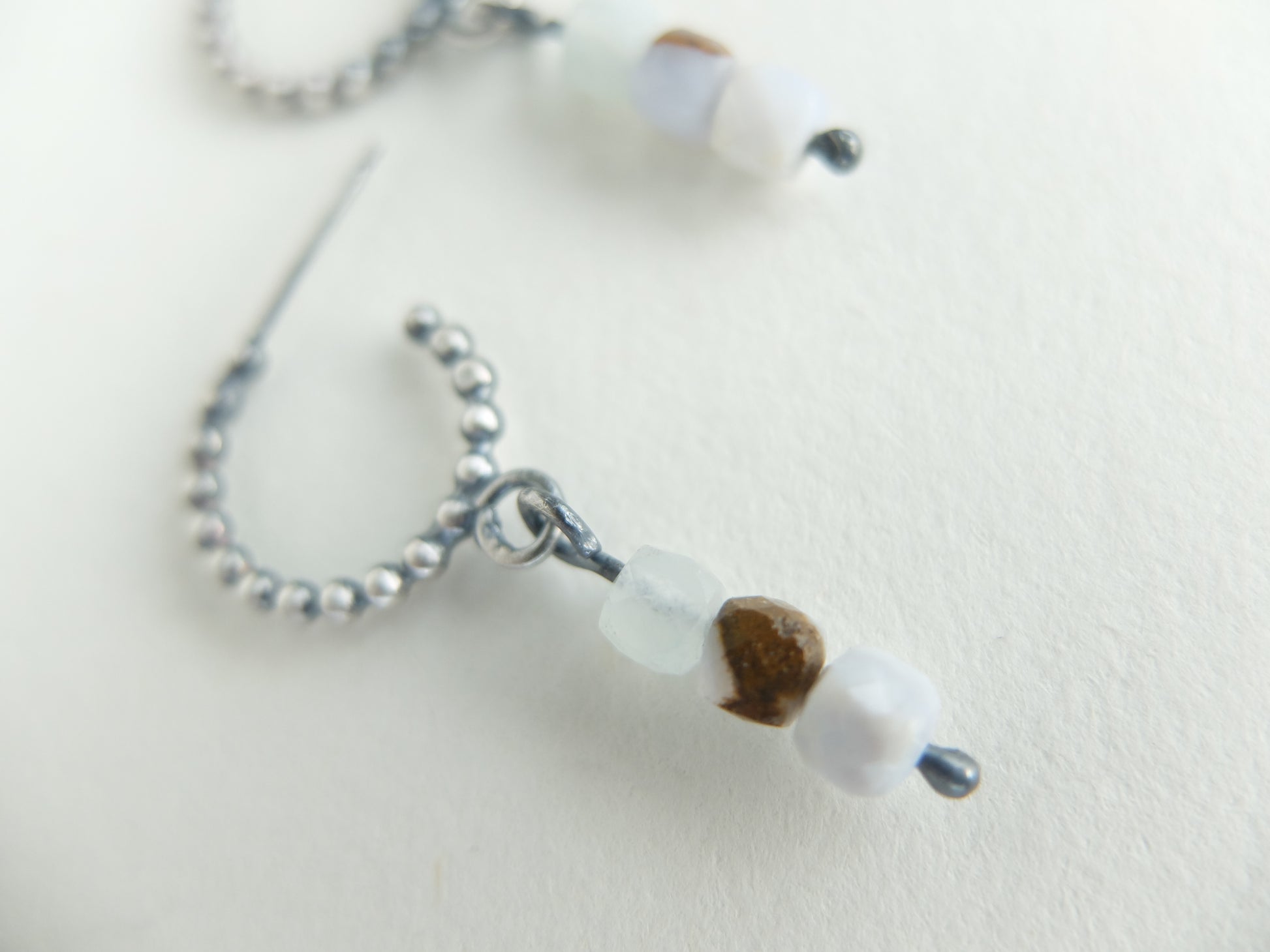 Close-up of a beaded earring with a focus on a single bead on a light background