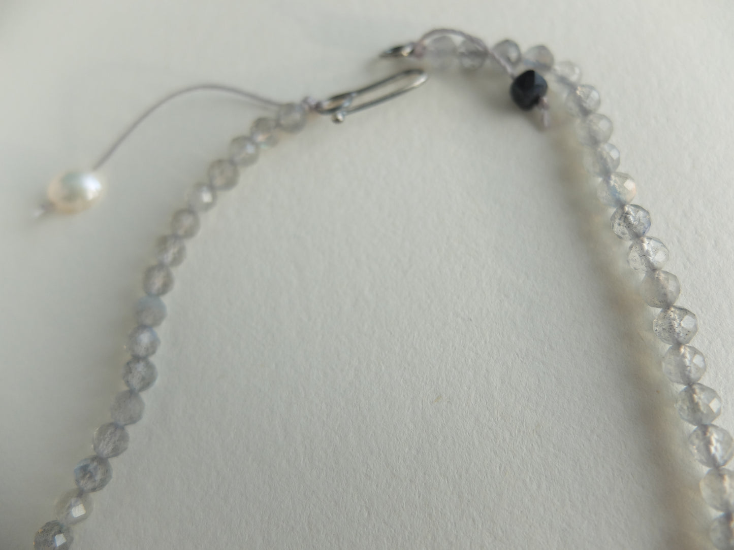 Necklace with clear beads and a clasp on a light gray background
