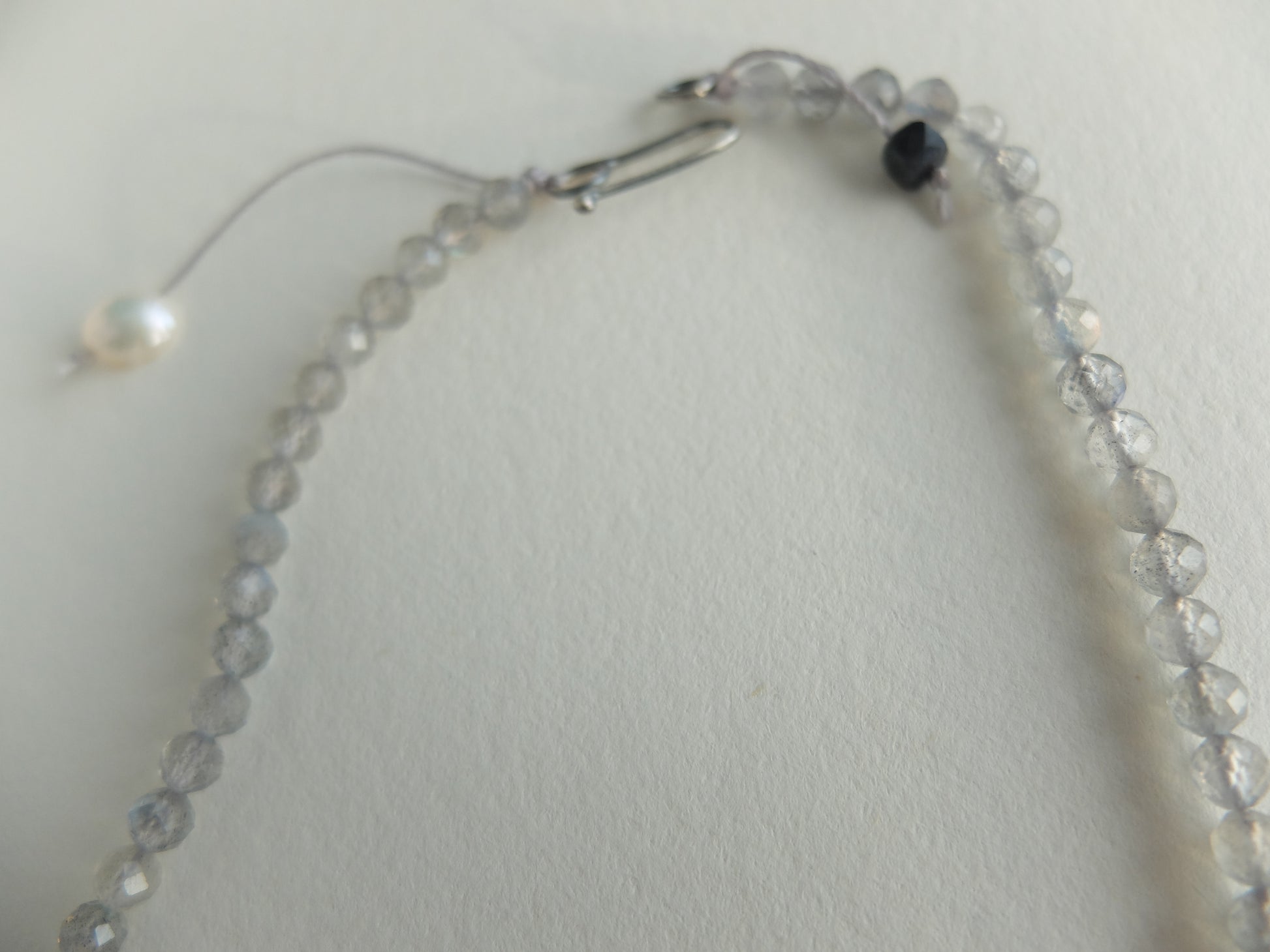 Necklace with clear beads and a clasp on a light gray background