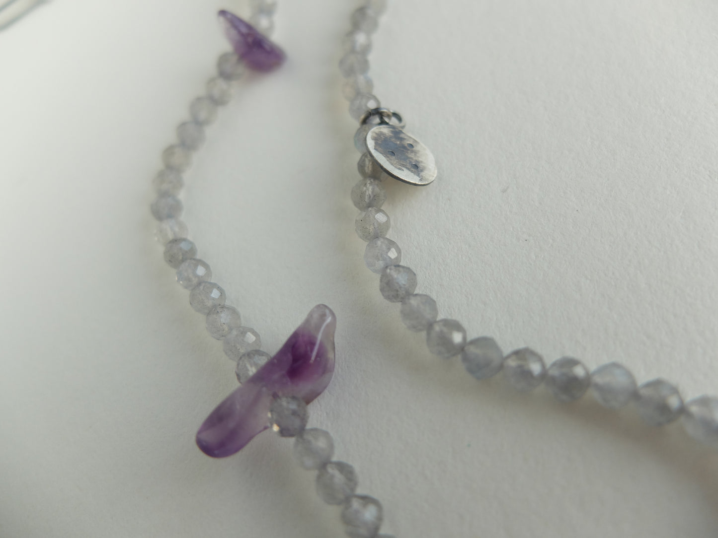 Necklace with purple pendant on a white background