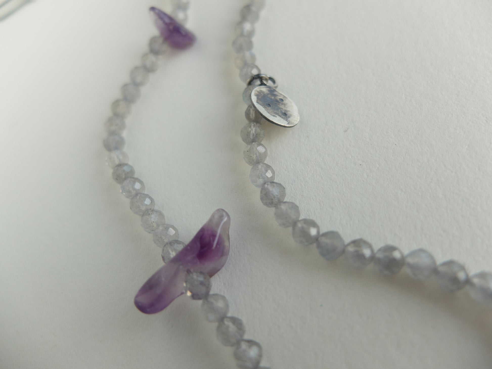 Necklace with purple pendant on a white background
