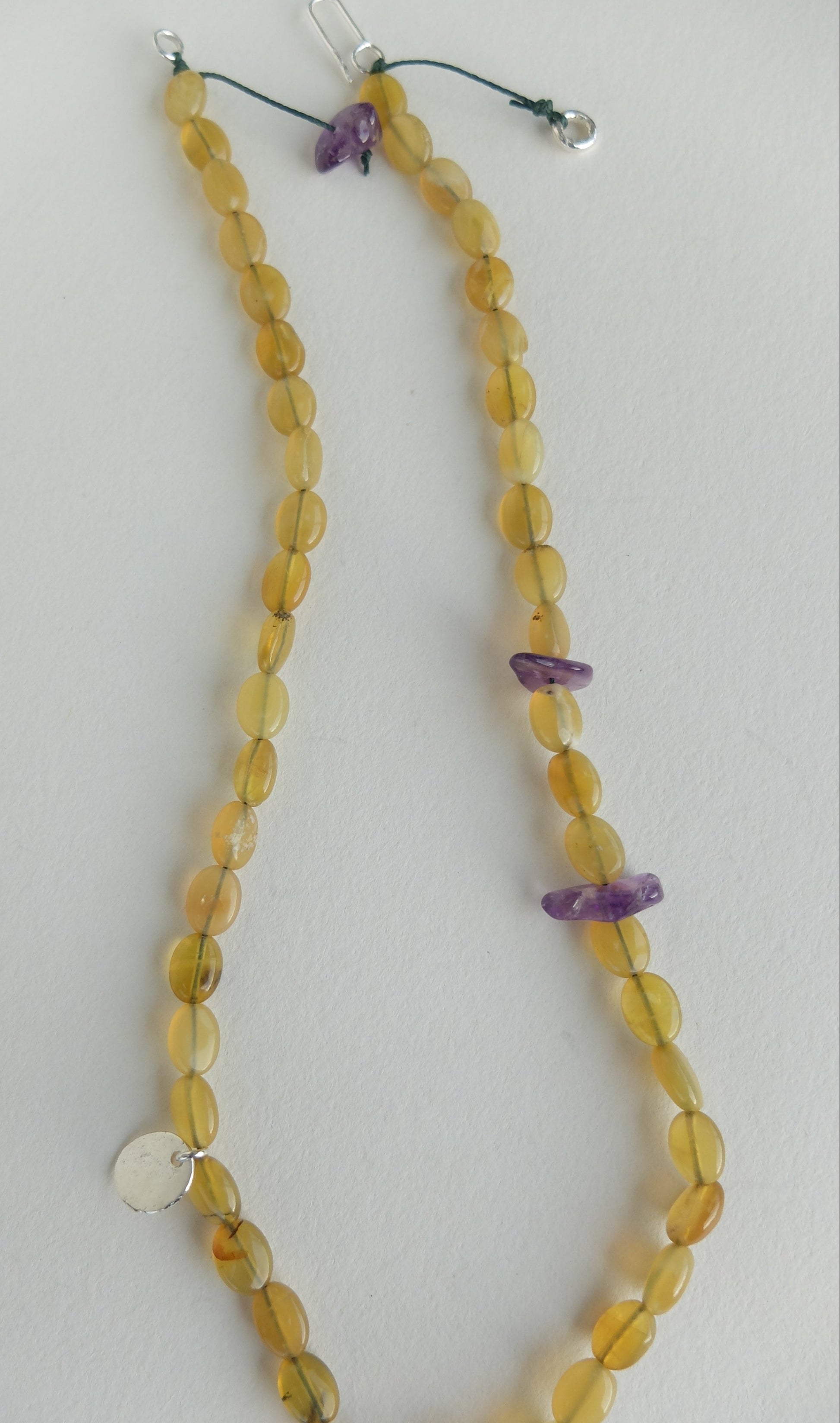 Necklace with yellow beads and purple accents on a white background