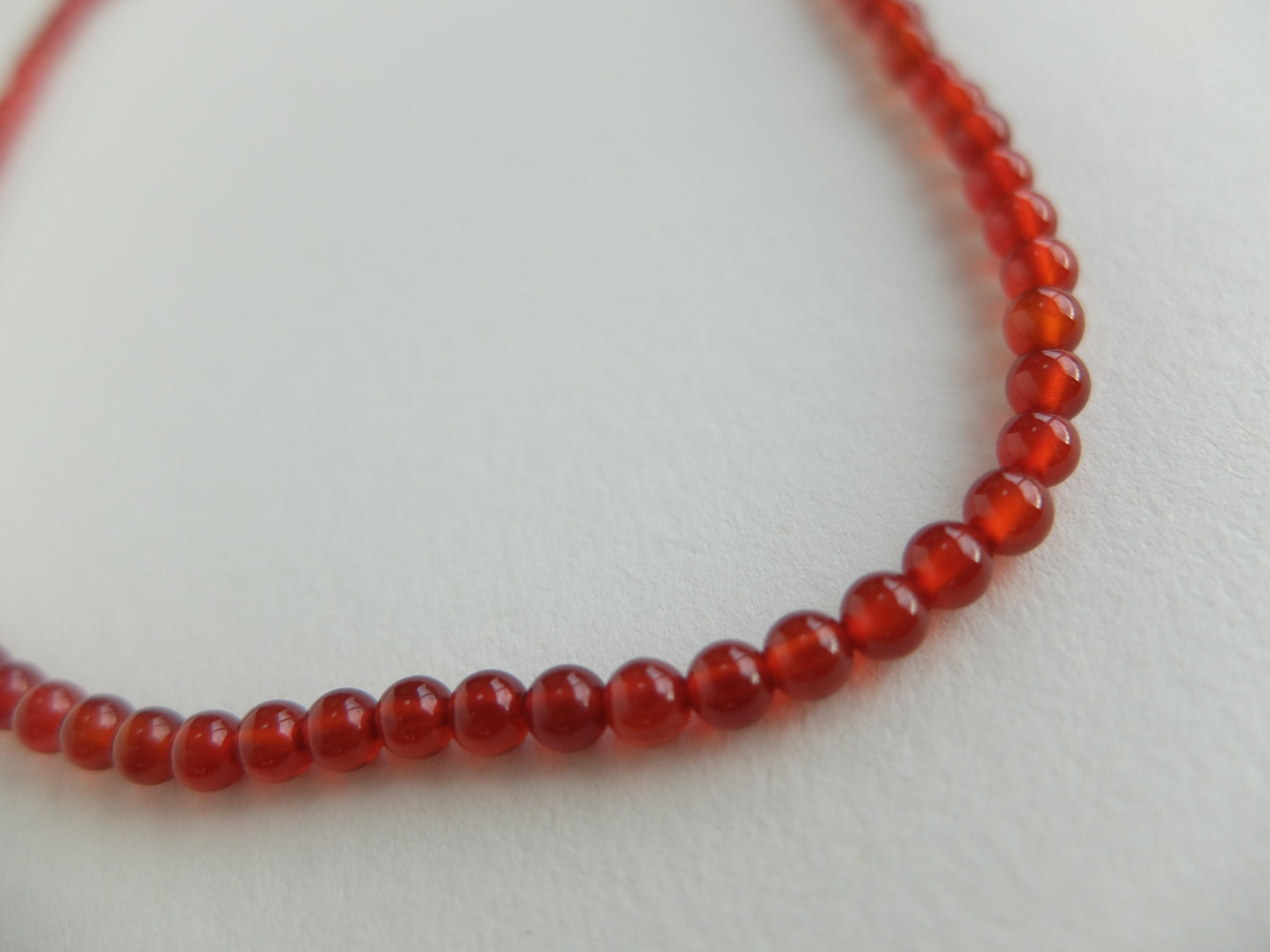 Red beaded necklace on a light gray background