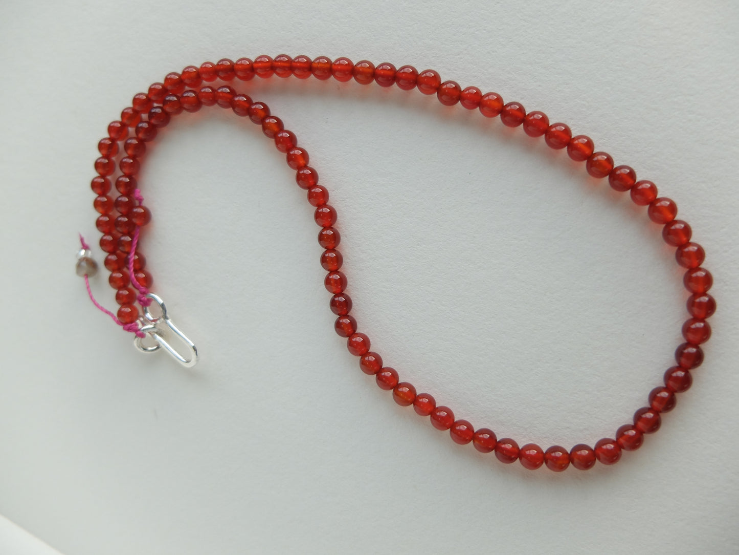 Red beaded necklace on a white background