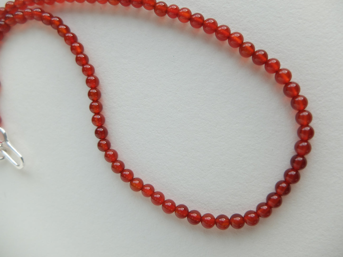 Red beaded necklace on a white background