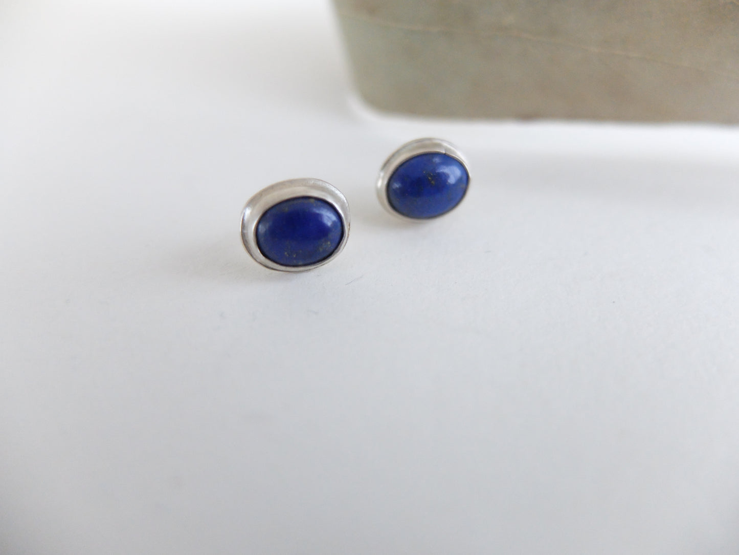 Pair of blue stud earrings on a white background