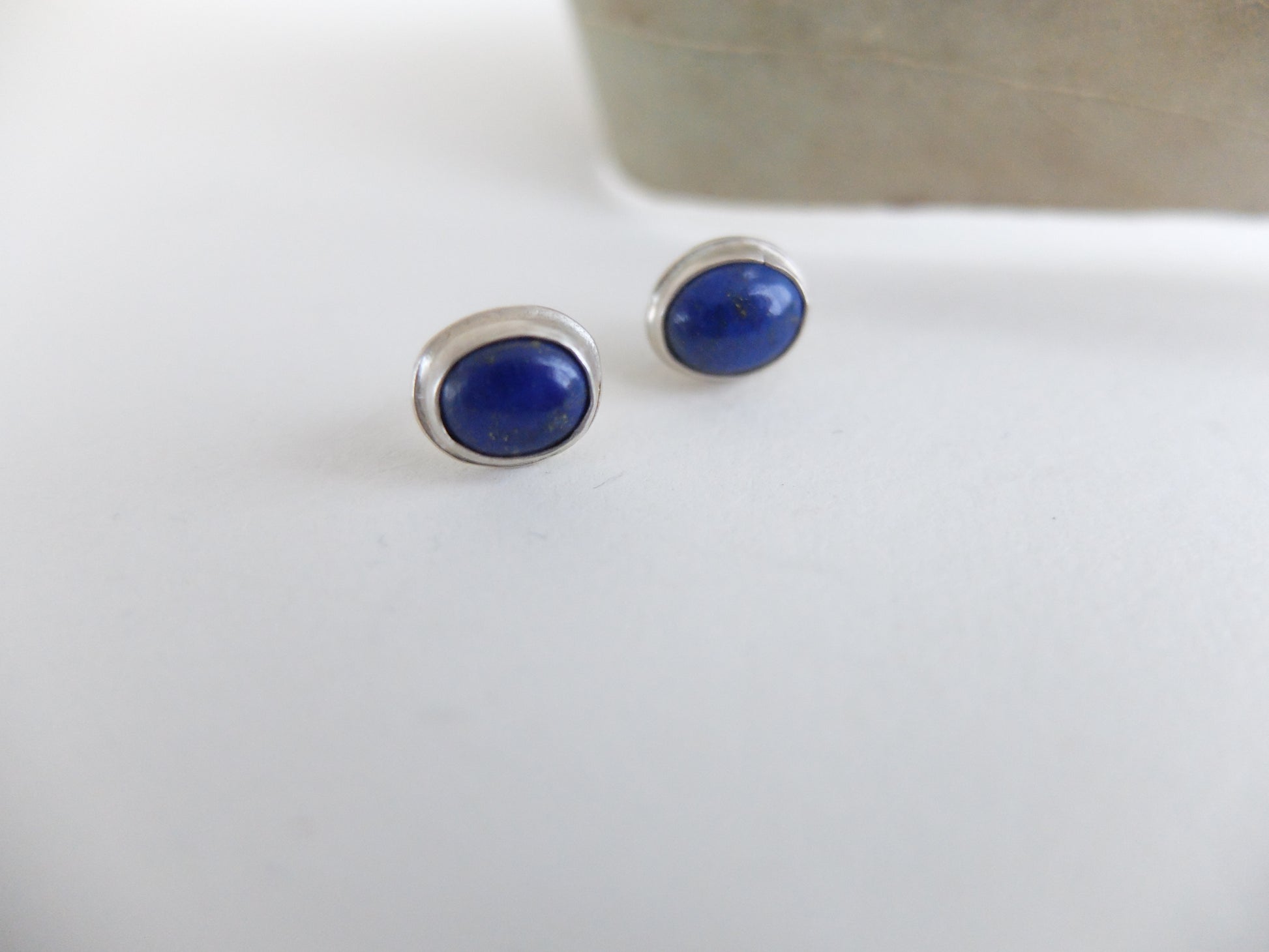 Pair of blue stud earrings on a white background