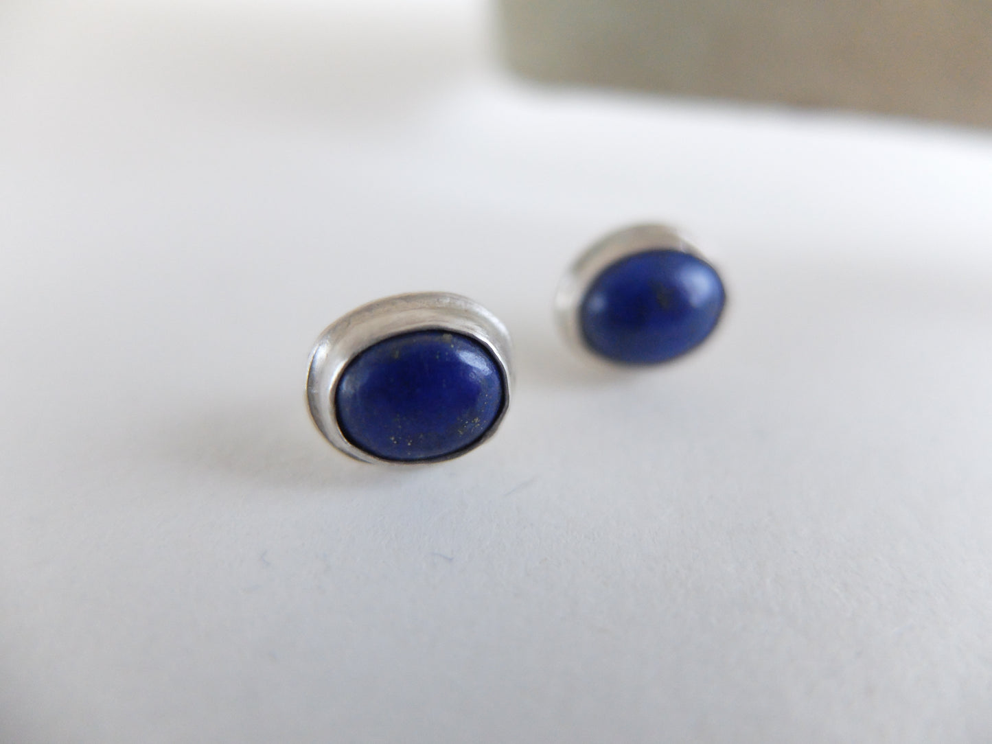 Pair of blue stone stud earrings on a white background