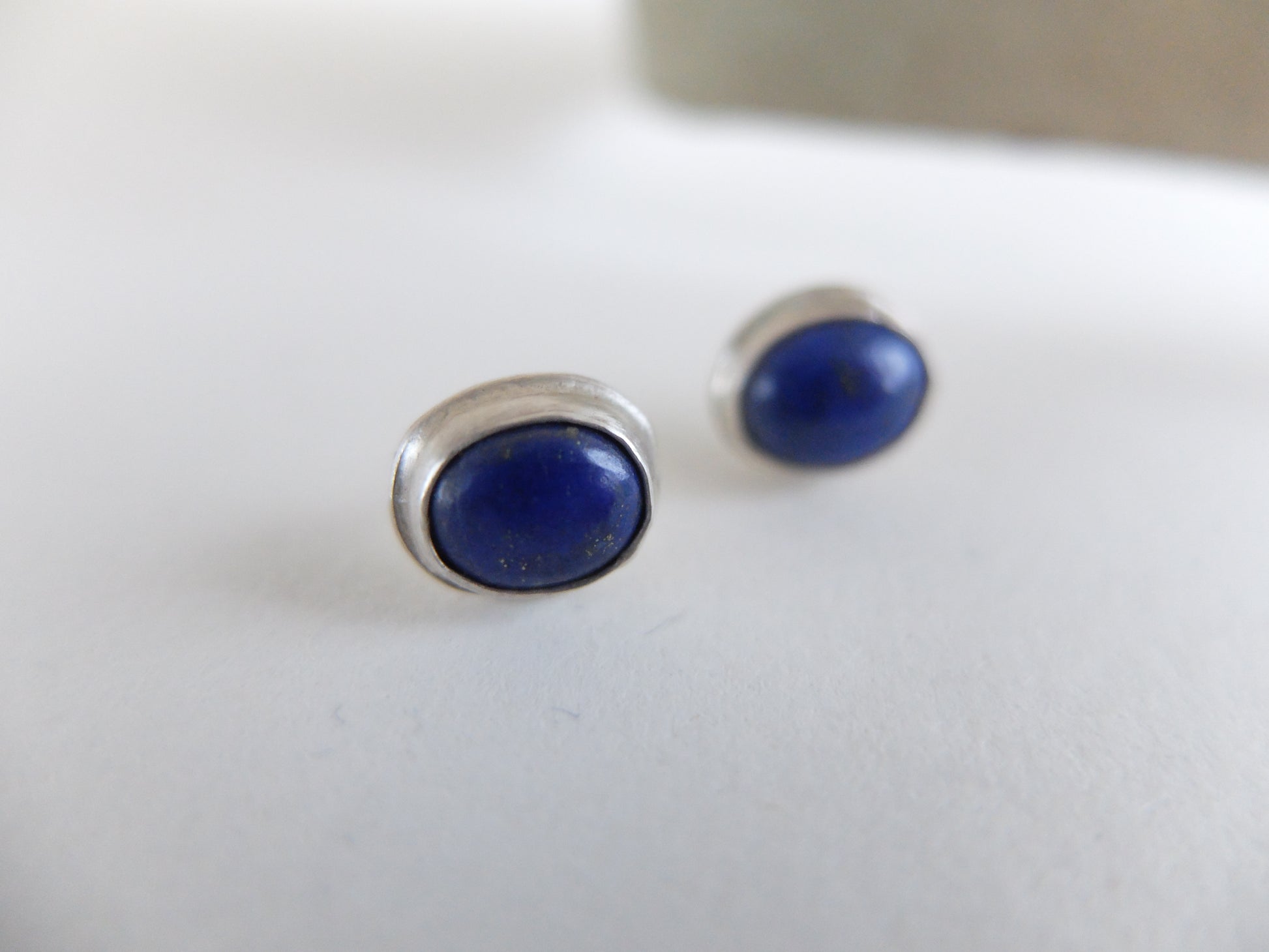 Pair of blue stone stud earrings on a white background