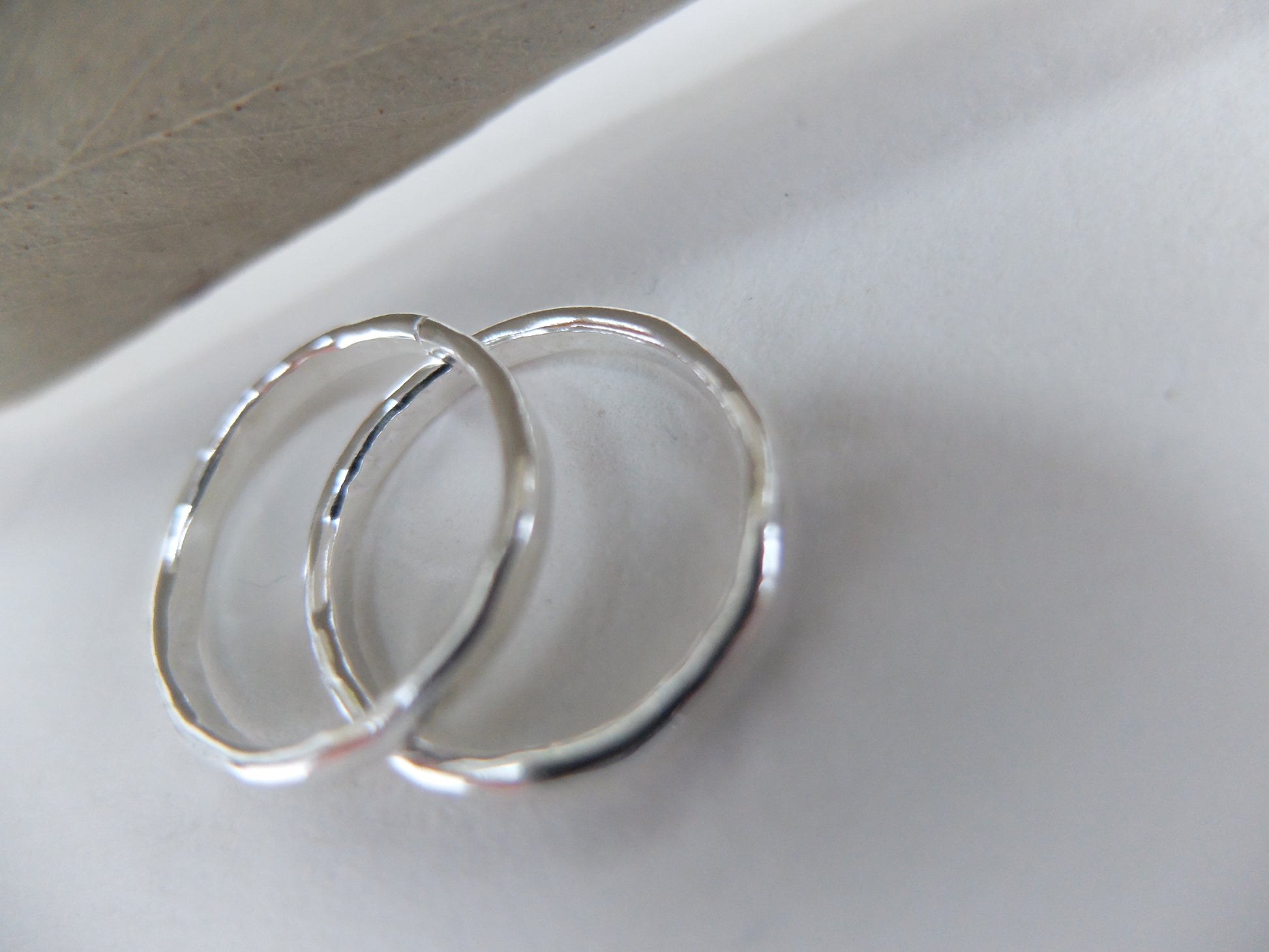 Two silver rings on a light background