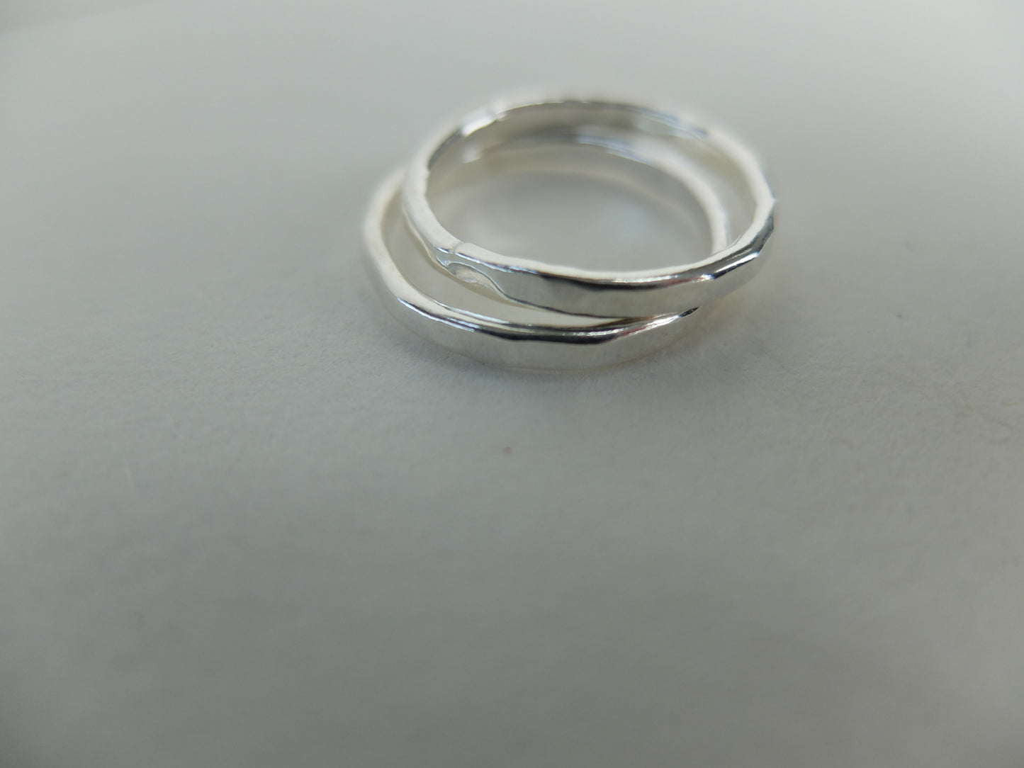 Two silver rings stacked on a light gray background
