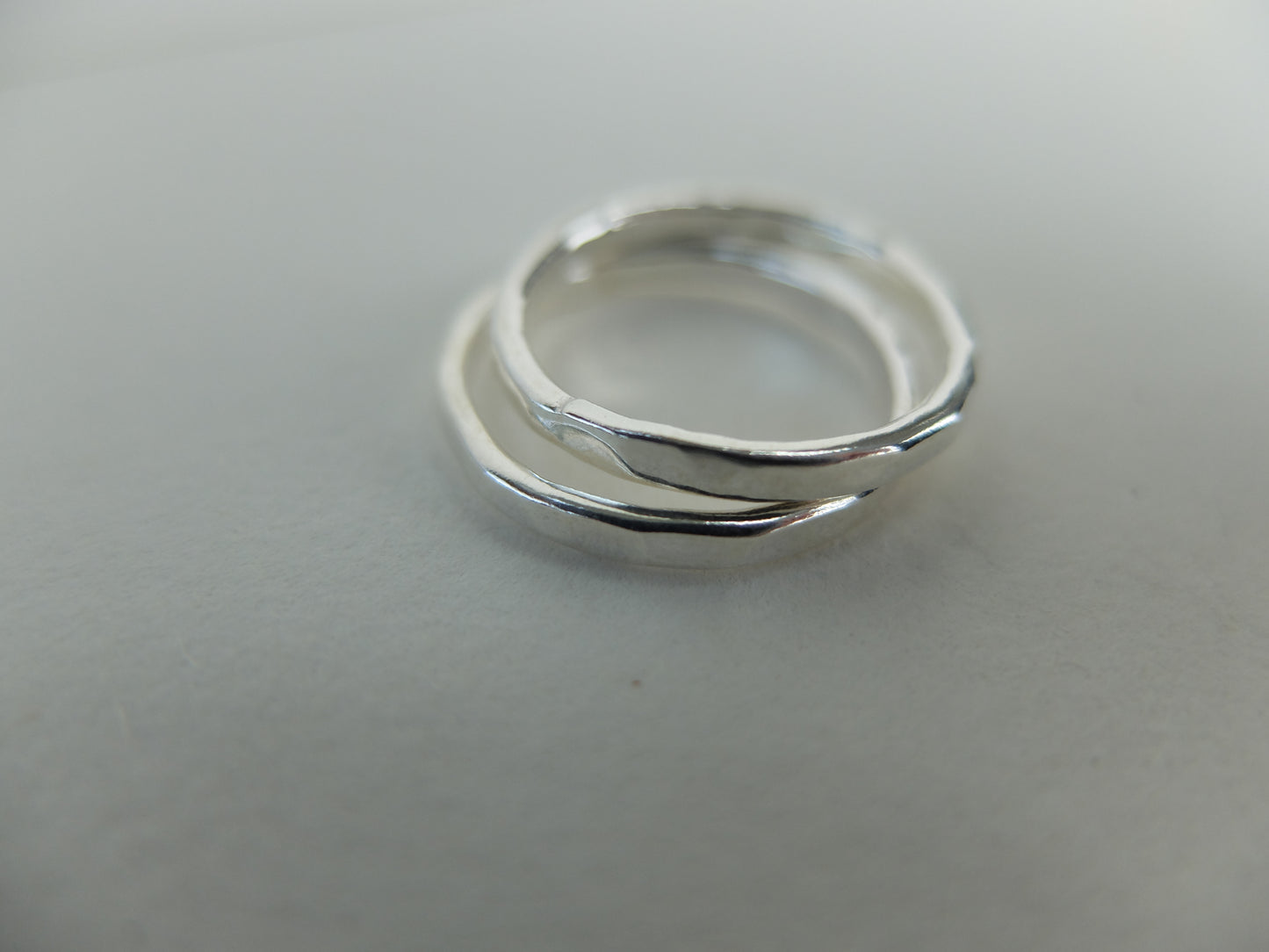 Two silver rings stacked on a light gray background