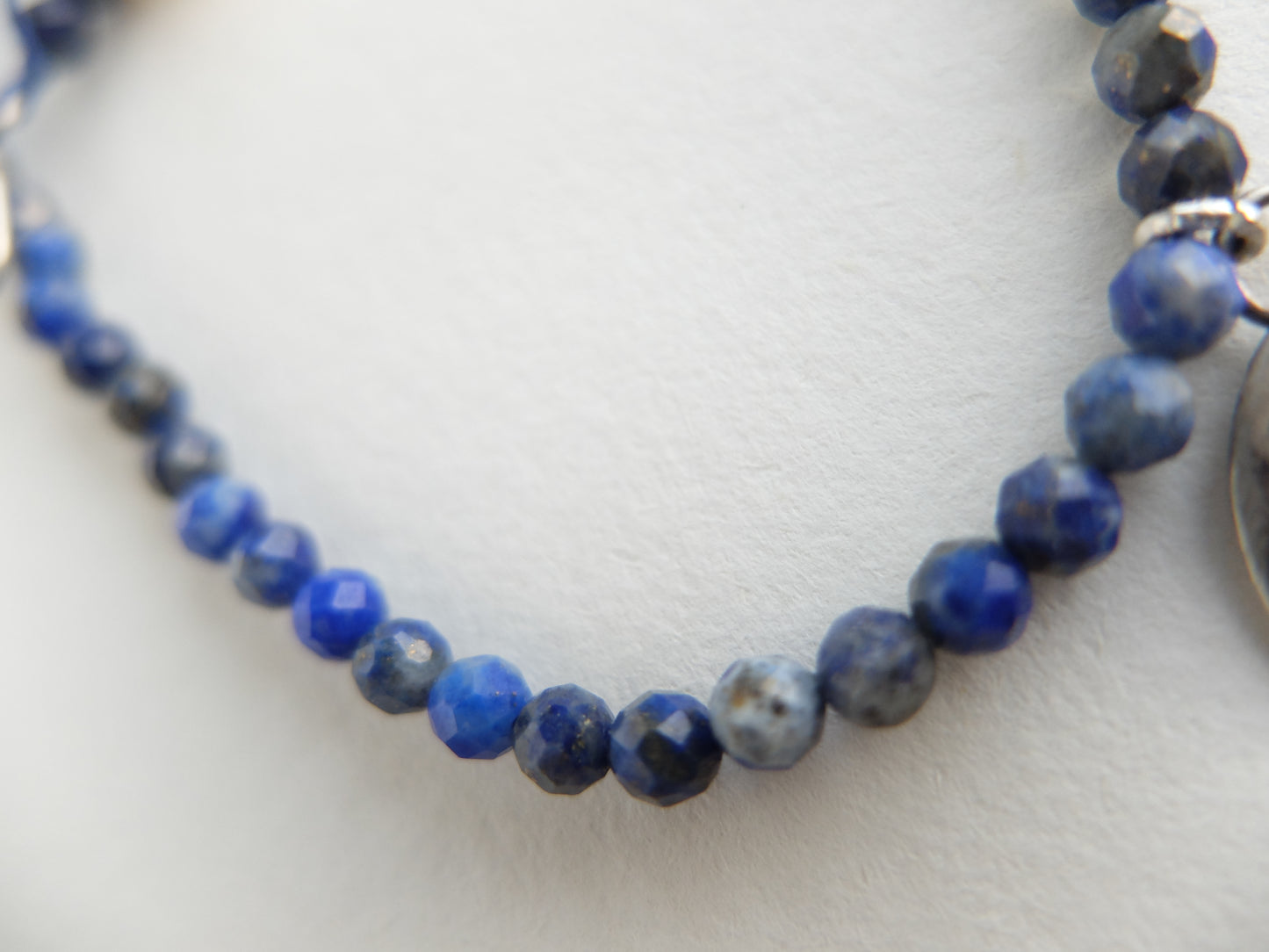 Blue beaded necklace on a light gray background