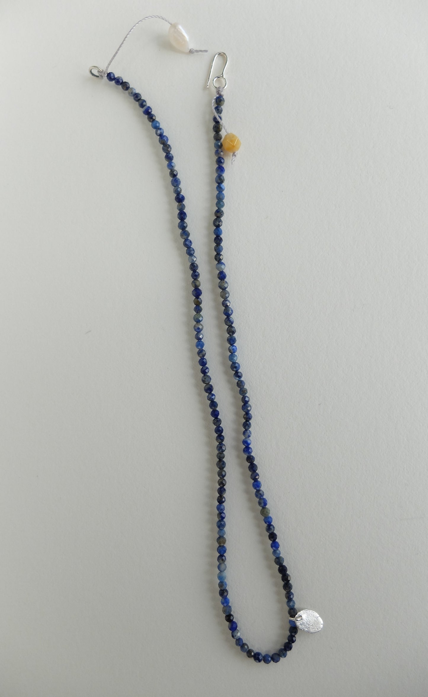 Beaded necklace with a silver clasp on a light gray background