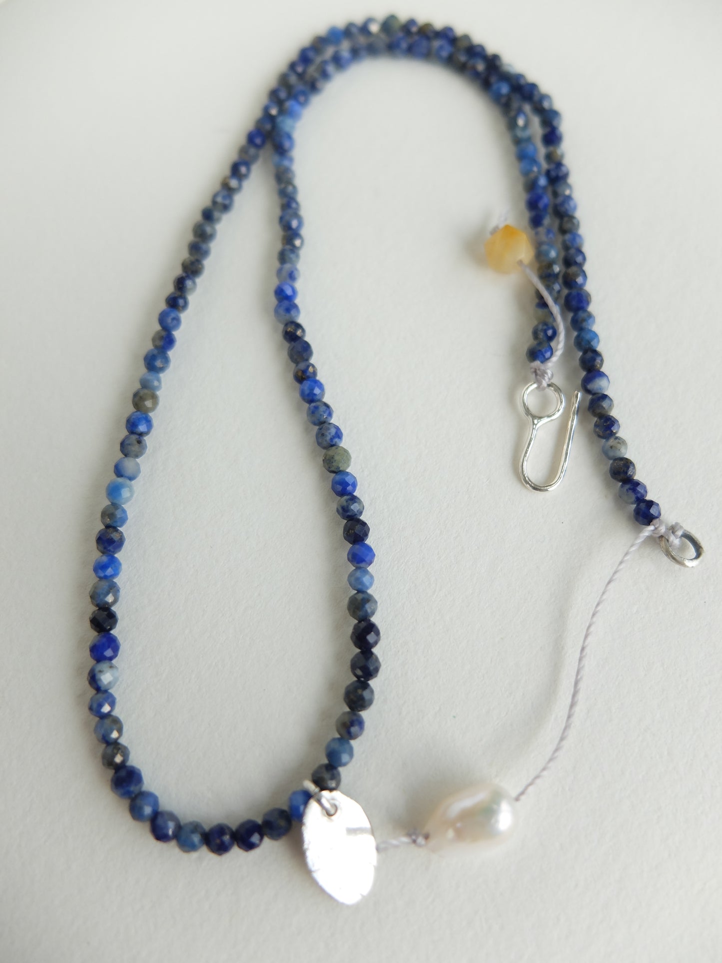 Beaded necklace with blue and black stones on a white background